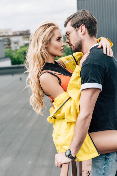 sarışın kadın ve yakışıklı adam sarılmak ve birbirlerine bakıyor  - Fotoğraf, Görsel