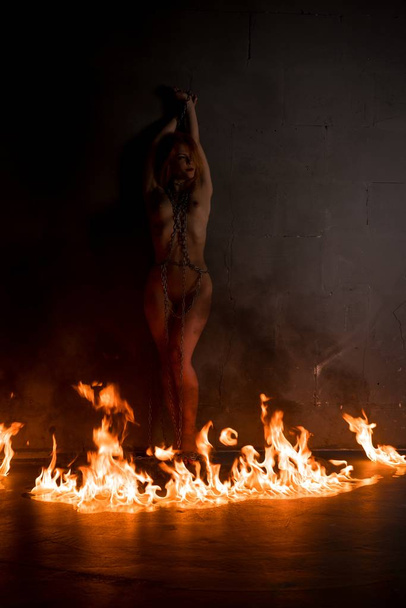 Naked attractive woman standing in fire circle - Photo, Image