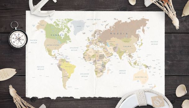 Weltkarte auf altem Papier, umgeben von Kompass, Anker, Rettungsring und Muscheln. - Foto, Bild