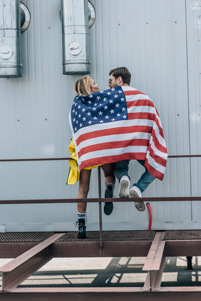 back view of woman and man with american flag on roof  - Photo, Image