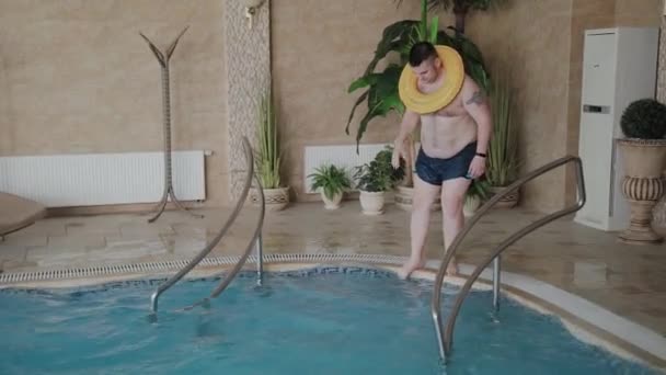 インフレータブルサークルでプールで泳ぐ陽気な男. - 映像、動画