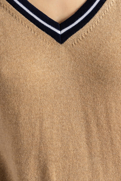 Textura de suéter de lana de punto marrón en el cuerpo humano. Fondo texturizado vertical. Línea del cuello en V
. - Foto, Imagen