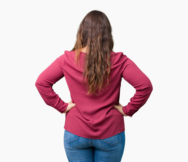 Gyönyörű, fiatal nő elszigetelt háttérben álló hátra keres el karral a test felett plusz - Fotó, kép