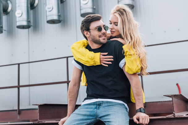 beautiful and blonde woman hugging handsome man in glasses  - Foto, afbeelding