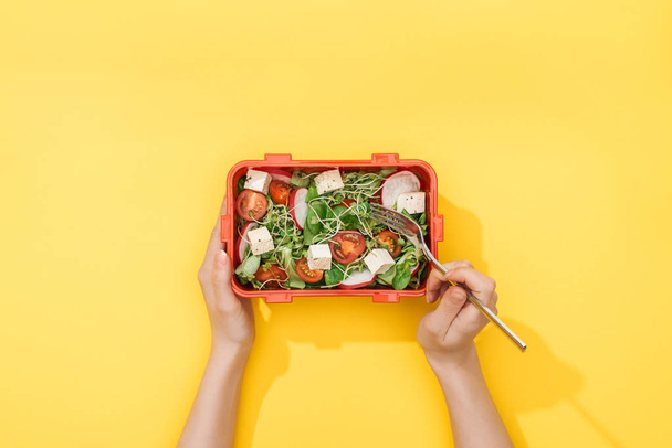 cropped view of woman holding fork and lunch box with salad in hands - Photo, Image