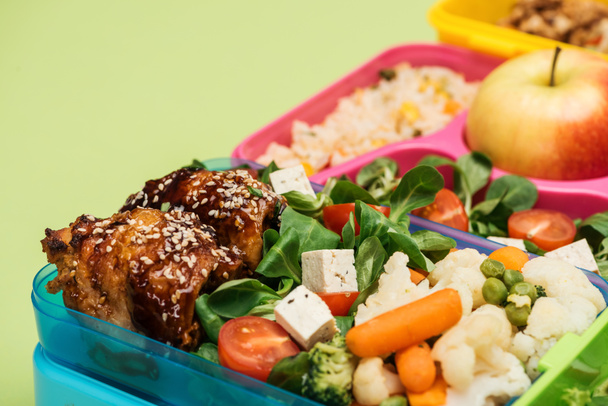 close up view of meal in lunch boxes isolated on green - Photo, Image
