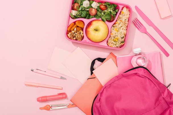 top view of lunch box with food near backpack and stationery - Photo, Image