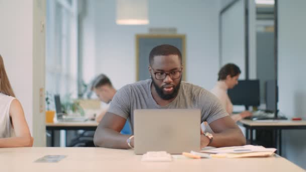 Homme afro heureux profiter de bons résultats sur ordinateur portable au bureau. Un homme choqué
 - Séquence, vidéo