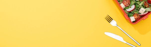 tiro panorâmico de lancheira com garfo e faca no fundo amarelo
 - Foto, Imagem