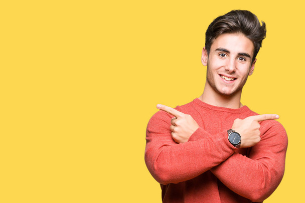 Young handsome man over isolated background Pointing to both sides with fingers, different direction disagree - Photo, Image