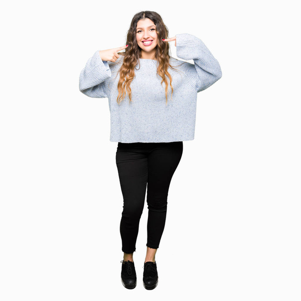 Young beautiful woman wearing winter sweater smiling confident showing and pointing with fingers teeth and mouth. Health concept. - Фото, изображение