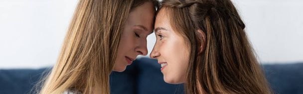 panoramic shot of two lesbians touching foreheads at home - Fotografie, Obrázek