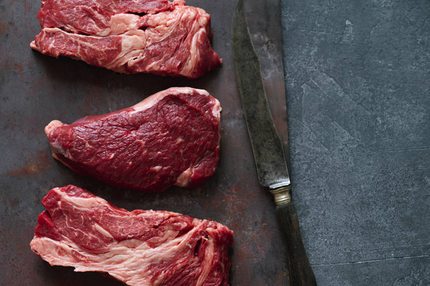 Raw black angus prime beef steaks variety on dark metallic background - 写真・画像