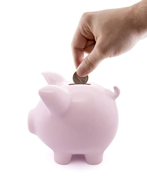 Putting coin into the piggy bank on white background  - Photo, image