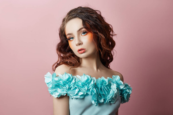 Beautiful makeup of sexy woman in turquoise dress on pink backgr - Fotó, kép