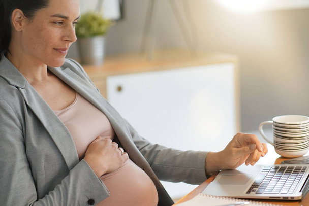 Pregnant businesswoman at work - Photo, image