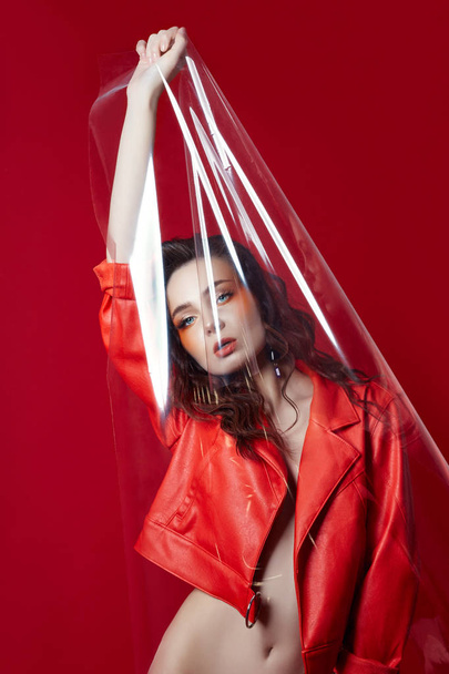Beautiful makeup of sexy Nude woman in red jacket on red  - 写真・画像