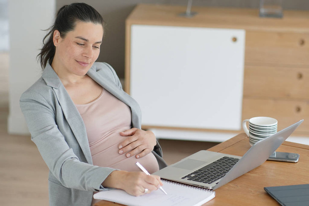 Pregnant businesswoman at work - Фото, зображення