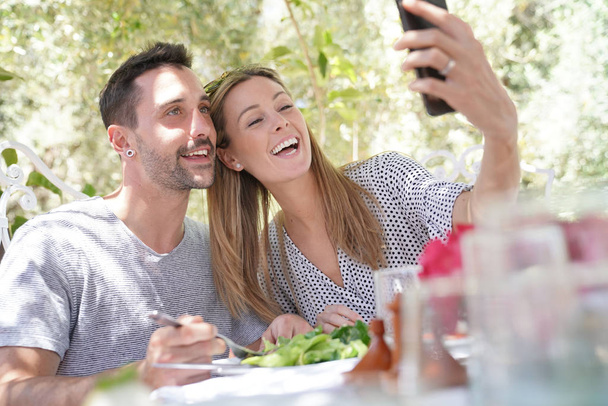 Happy couple taking sefie during outdoor lunch - Foto, Imagem