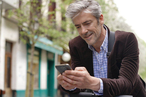 Mature man on cellphone in city centre  - Fotografie, Obrázek