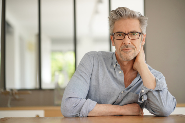 Portrait of handsome mature man wearing glasses smiling at camera - Photo, Image