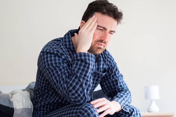 Nemocný muž v posteli cítí bolest hlavy - Fotografie, Obrázek