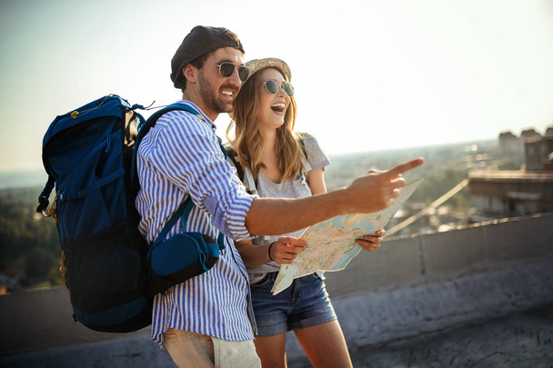 Happy young couple on vacation sightseeing city with map - Photo, Image