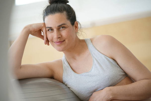 Portrait of pregnant woman leaning on fitness ball - Foto, afbeelding