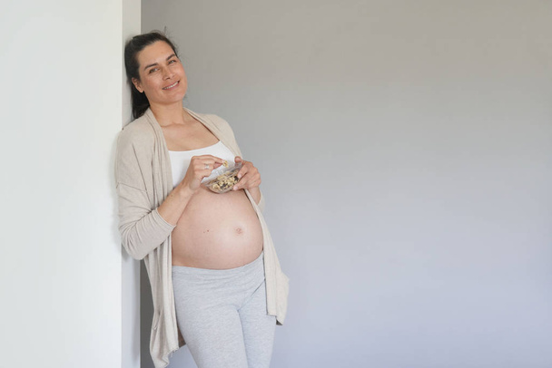Pregnant woman eating cereals, isolated - Φωτογραφία, εικόνα