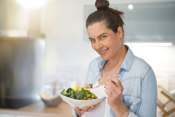 Mulher grávida em casa cozinha comer salada saudável
 - Foto, Imagem