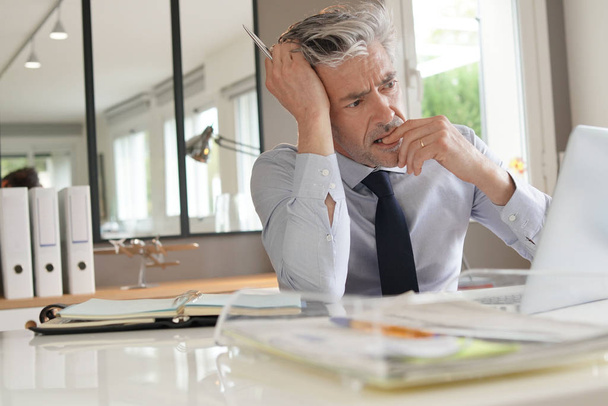Stressed businessman working in contemporary office - Photo, image
