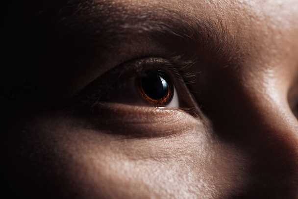 Close-up van het menselijk bruine oog op zoek weg - Foto, afbeelding
