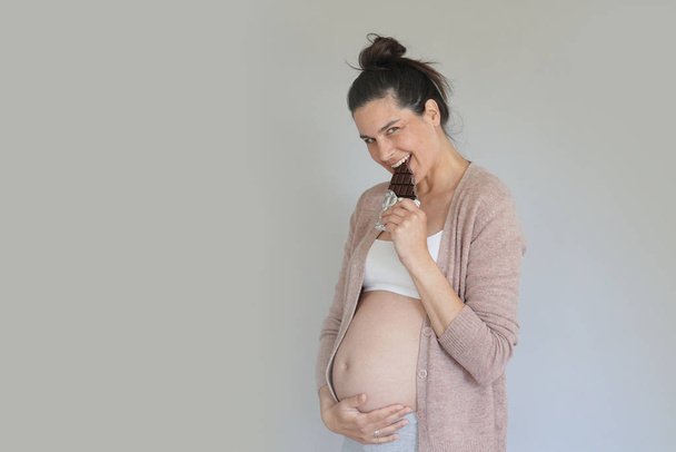 Mujer embarazada anhelo de barra de chocolate, aislado
 - Foto, imagen