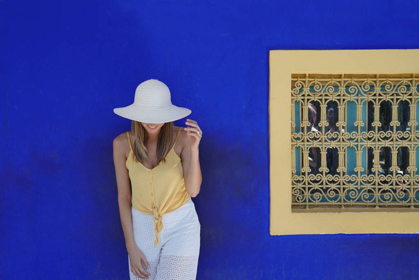 Stunning woman against blue wall in Majorelle Garden Morocco - Fotoğraf, Görsel
