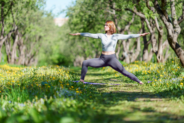 Wizerunek kobiety z rąk do boku ćwiczenia jogi w lesie po południu - Zdjęcie, obraz