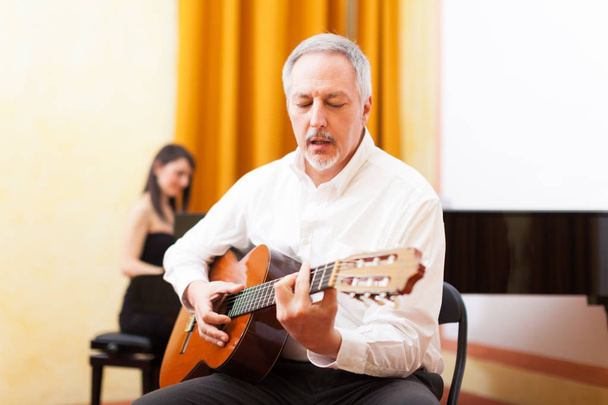 Guitarist playing an acoustic guitar - Fotografie, Obrázek