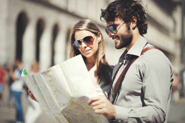Happy tourists couple holding map - Photo, Image