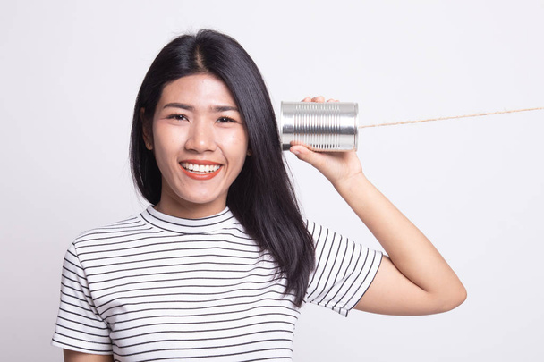 Young Asian woman with tin can phone. - Foto, Imagen