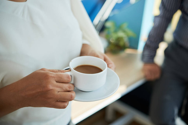 Cup of coffee with milk in hands of business woman - Foto, Bild