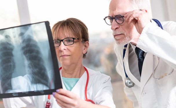 Deux médecins examinent un rapport de radiographie
 - Photo, image