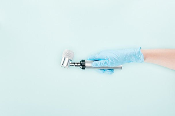 обрізаний вид лікаря в латексній рукавичці, що тримає дерматоскоп ізольовано на синьому
 - Фото, зображення