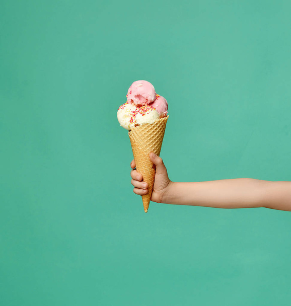 Baby kid hand holding big ice-cream in waffles cone on blue - Fotografie, Obrázek