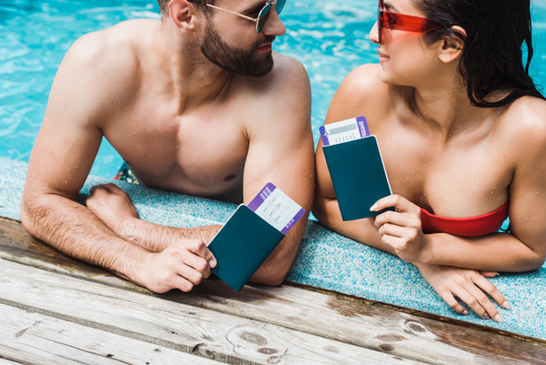 man and woman in sunglasses holding passports with air tickets  - Photo, Image