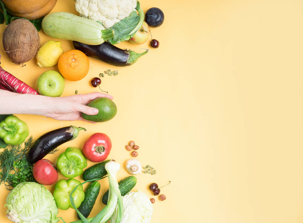Naisten käsi tilalla avokado hedelmiä taustalla hedelmiä ja vihanneksia, vegaani valinta, terveellistä ruokaa, Zoh
, - Valokuva, kuva