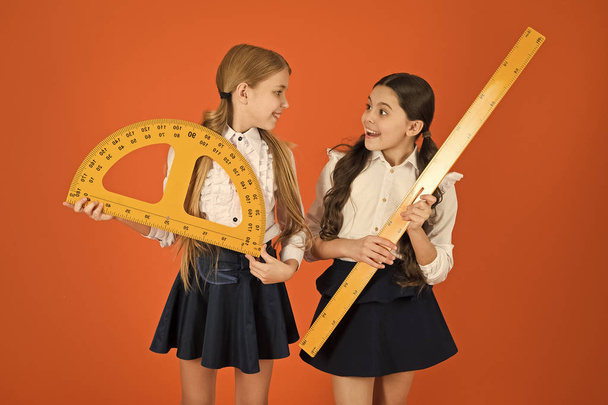 For good measure. School children with measuring instruments. Little girls ready for geometry lesson. Small girls are back to school. Cute schoolgirls holding protractor and ruler for lesson - Photo, image