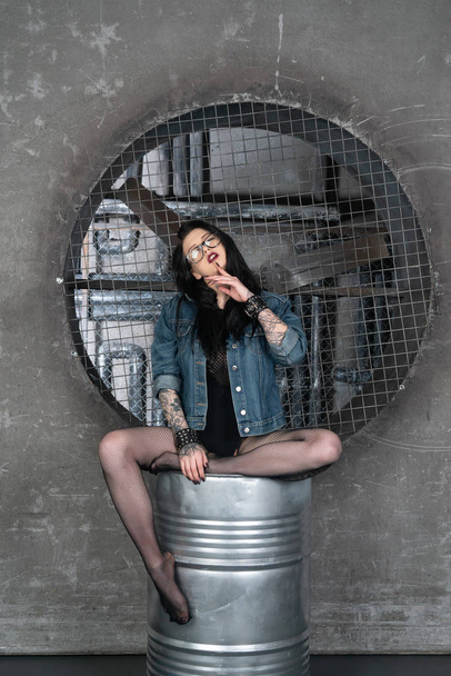 young beautiful girl posing in the studio, sitting in a denim jacket - Photo, Image