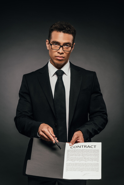 african american businessman showing contract on dark background - Photo, image
