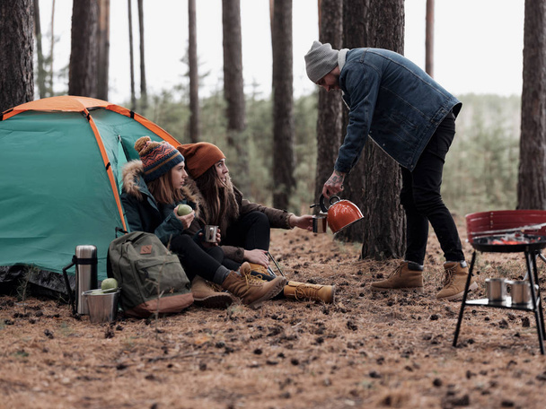 Group of friends having tea at campsite - Valokuva, kuva