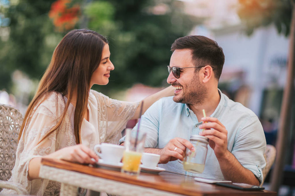 Όμορφη αγάπη ζευγάρι κάθεται σε μια καφετέρια απολαμβάνοντας τον καφέ και - Φωτογραφία, εικόνα