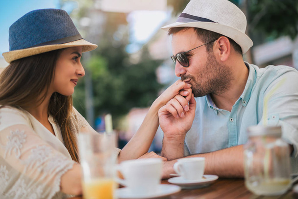 Beautiful loving couple sitting in a cafe enjoying in coffee and - Foto, Imagen